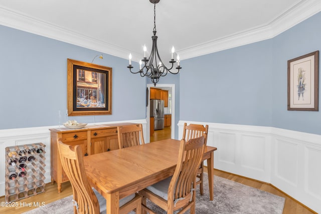 1514 Grandiflora Dr, Leland, NC 28451 - dining room featuring a chandelier, ornamental molding, a wainscoted wall, and light wood-style flooring