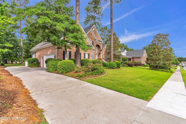 1514 Grandiflora Dr, Leland, NC 28451 - view of front of house featuring brick siding, concrete driveway, a front lawn, and a garage