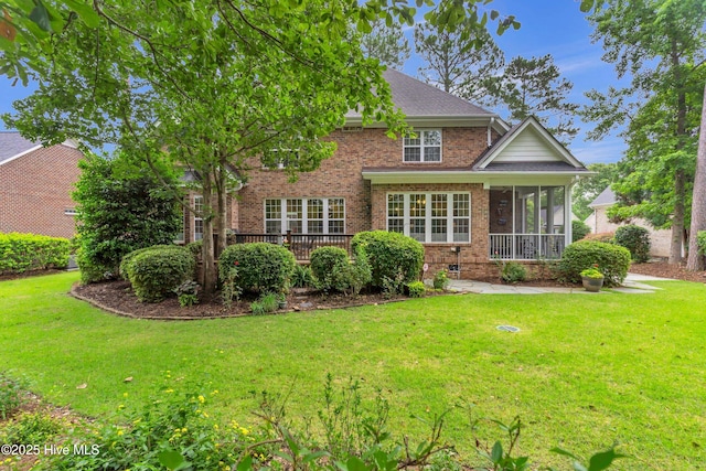 1514 Grandiflora Dr, Leland, NC 28451 - rear view of house featuring brick siding, a sunroom, a yard, and a deck
