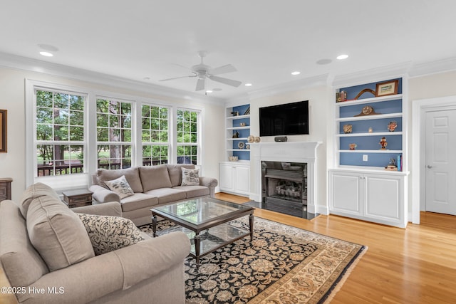 1514 Grandiflora Dr, Leland, NC 28451 - living room with crown molding, a ceiling fan, light wood-style floors, a fireplace, and built in features