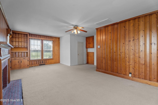 6074 NC-42 Hwy W, Macclesfield, NC 27852 - unfurnished living room with wood walls, ceiling fan, carpet flooring, and a brick fireplace