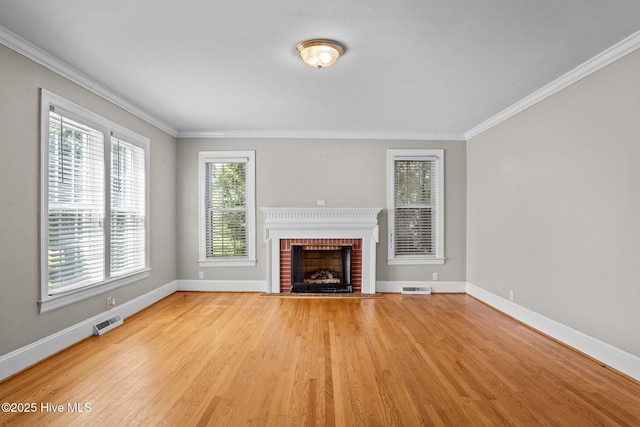 6074 NC-42 Hwy W, Macclesfield, NC 27852 - unfurnished living room featuring crown molding, light wood-style floors, plenty of natural light, and a fireplace