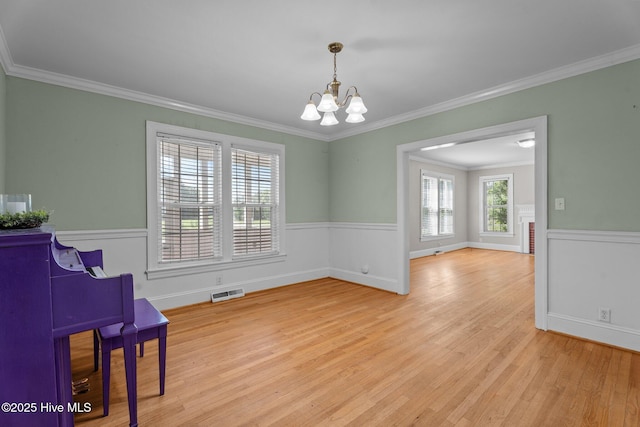 6074 NC-42 Hwy W, Macclesfield, NC 27852 - living area featuring a chandelier, crown molding, wood finished floors, and a wainscoted wall