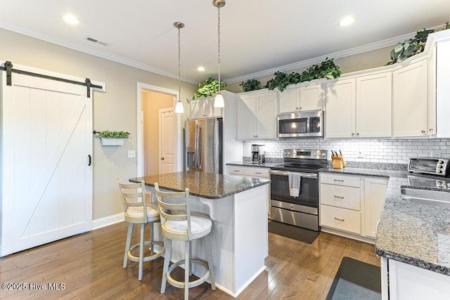26 Calhoun Ln, Pinehurst, NC 28374 - kitchen featuring appliances with stainless steel finishes, wood finished floors, backsplash, a center island, and recessed lighting