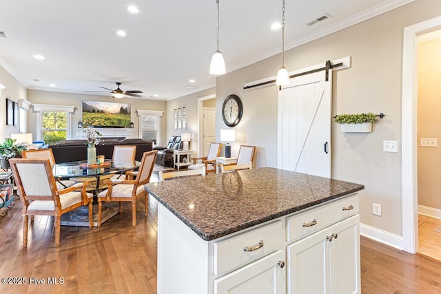 26 Calhoun Ln, Pinehurst, NC 28374 - kitchen featuring recessed lighting, light wood-style floors, a barn door, ceiling fan, and decorative light fixtures