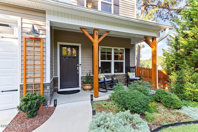 26 Calhoun Ln, Pinehurst, NC 28374 - property entrance featuring covered porch, stone siding, and a garage