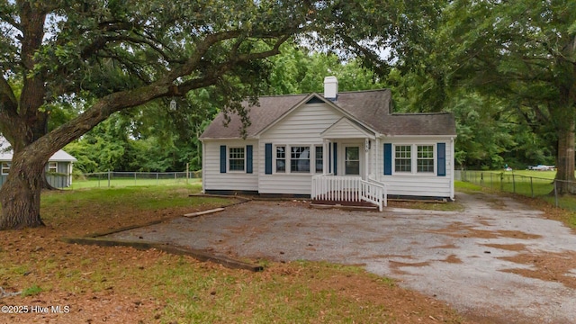 350 Hubert Blvd, Hubert, NC 28539 - view of front of house with a chimney, a fenced backyard, a shingled roof, and view of scattered trees