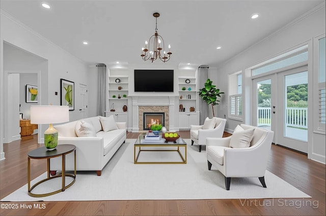 311 S Kingfisher Ln, Hampstead, NC 28443 - living room with wood finished floors, recessed lighting, a chandelier, a warm lit fireplace, and crown molding