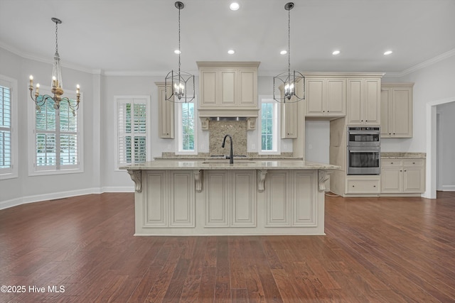 311 S Kingfisher Ln, Hampstead, NC 28443 - kitchen featuring a chandelier, stainless steel double oven, cream cabinets, dark wood-style floors, and ornamental molding