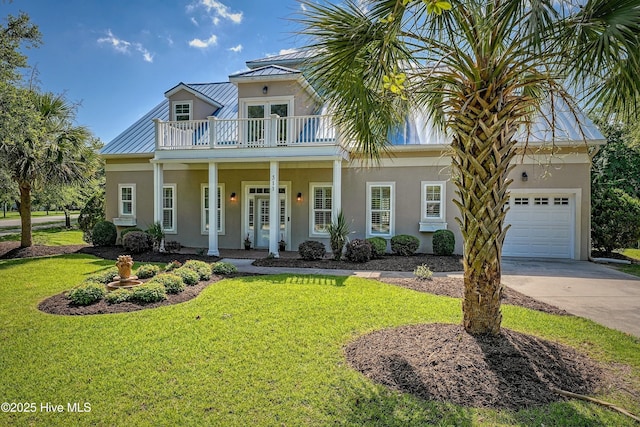 311 S Kingfisher Ln, Hampstead, NC 28443 - view of front of home featuring a balcony, a standing seam roof, driveway, a metal roof, and a front yard