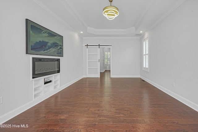 311 S Kingfisher Ln, Hampstead, NC 28443 - unfurnished living room featuring a barn door, wood finished floors, a raised ceiling, crown molding, and built in features