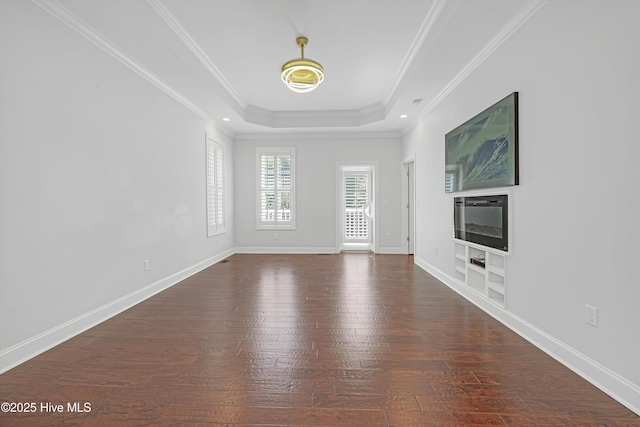 311 S Kingfisher Ln, Hampstead, NC 28443 - unfurnished living room featuring hardwood / wood-style flooring, ornamental molding, a raised ceiling, built in shelves, and recessed lighting