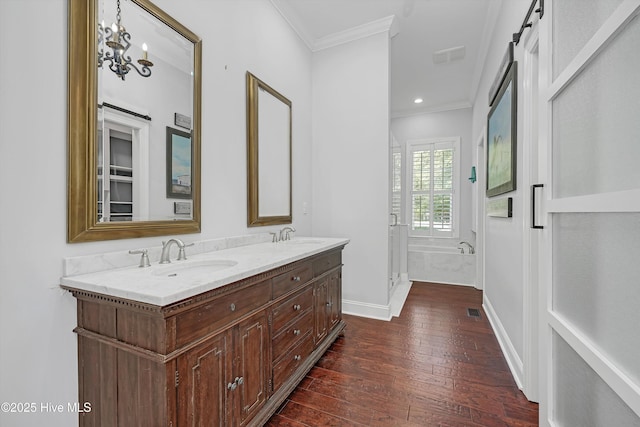 311 S Kingfisher Ln, Hampstead, NC 28443 - full bath with ornamental molding, hardwood / wood-style floors, double vanity, recessed lighting, and a bath