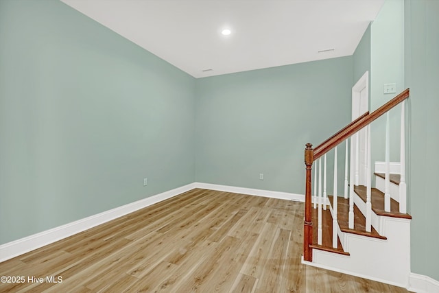 311 S Kingfisher Ln, Hampstead, NC 28443 - spare room featuring wood finished floors, stairway, and recessed lighting