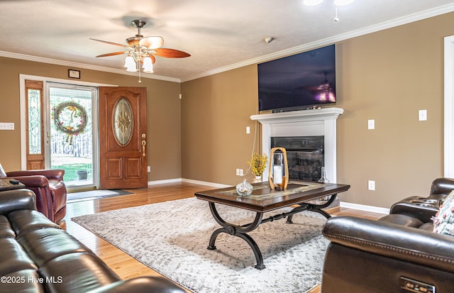 409 S Grace Chapel Church Rd, Hamlet, NC 28345 - living area featuring wood finished floors, ceiling fan, a glass covered fireplace, and ornamental molding