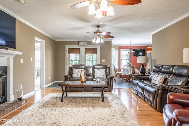 409 S Grace Chapel Church Rd, Hamlet, NC 28345 - living area featuring a ceiling fan, a glass covered fireplace, ornamental molding, wood finished floors, and a textured ceiling