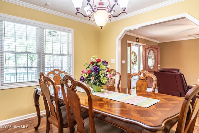 409 S Grace Chapel Church Rd, Hamlet, NC 28345 - dining space featuring a chandelier, plenty of natural light, arched walkways, wood finished floors, and crown molding