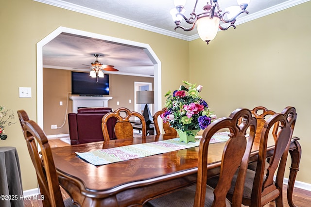 409 S Grace Chapel Church Rd, Hamlet, NC 28345 - dining room with a chandelier, ceiling fan, crown molding, wood finished floors, and arched walkways