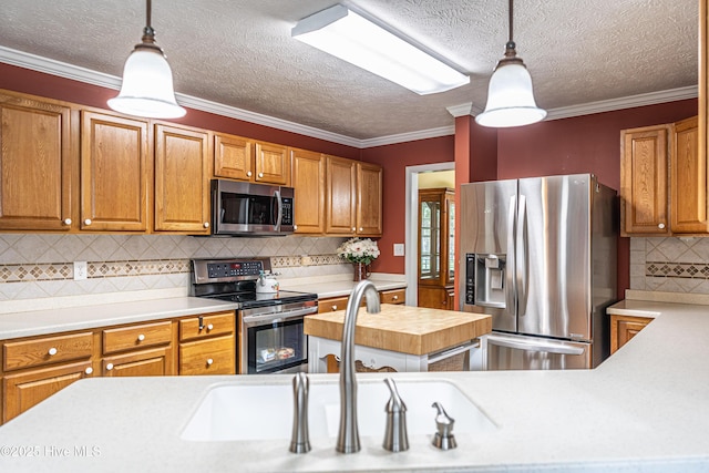 409 S Grace Chapel Church Rd, Hamlet, NC 28345 - kitchen with appliances with stainless steel finishes, tasteful backsplash, hanging light fixtures, crown molding, and brown cabinets