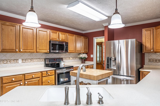 409 S Grace Chapel Church Rd, Hamlet, NC 28345 - kitchen featuring stainless steel appliances, light countertops, decorative backsplash, hanging light fixtures, and brown cabinets