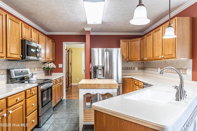 409 S Grace Chapel Church Rd, Hamlet, NC 28345 - kitchen featuring stainless steel appliances, light countertops, brown cabinets, backsplash, and hanging light fixtures
