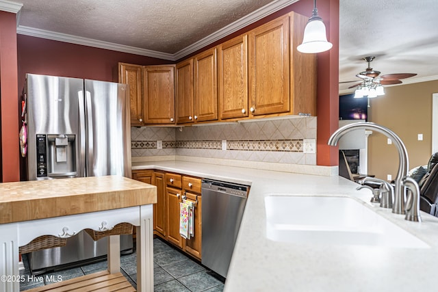 409 S Grace Chapel Church Rd, Hamlet, NC 28345 - kitchen with stainless steel appliances, brown cabinets, backsplash, a ceiling fan, and a textured ceiling