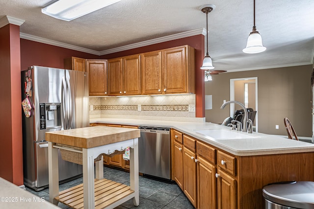 409 S Grace Chapel Church Rd, Hamlet, NC 28345 - kitchen with stainless steel appliances, a peninsula, decorative backsplash, brown cabinets, and ornamental molding