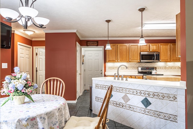 409 S Grace Chapel Church Rd, Hamlet, NC 28345 - kitchen featuring stainless steel appliances, dark tile patterned floors, light countertops, decorative backsplash, and crown molding