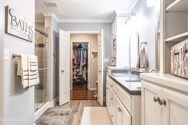 409 S Grace Chapel Church Rd, Hamlet, NC 28345 - full bath with a stall shower, double vanity, wood finished floors, a spacious closet, and ornamental molding