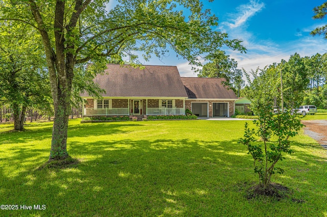 409 S Grace Chapel Church Rd, Hamlet, NC 28345 - cape cod house featuring covered porch, driveway, brick siding, and a front lawn