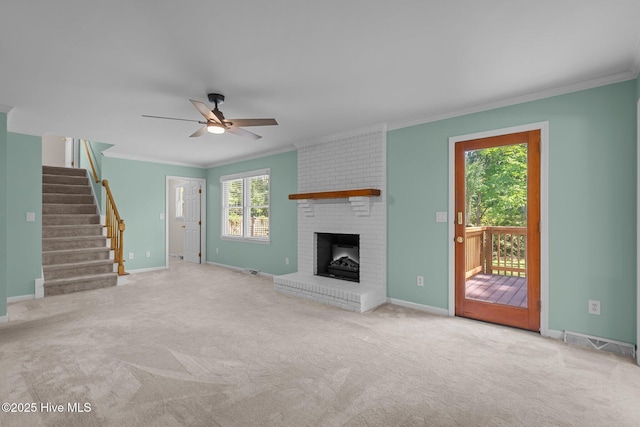 3313 Aster Ct, Wilmington, NC 28409 - unfurnished living room with ornamental molding, a ceiling fan, carpet flooring, a brick fireplace, and stairs