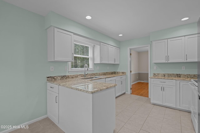 3313 Aster Ct, Wilmington, NC 28409 - kitchen with a peninsula, white cabinets, light tile patterned floors, light stone countertops, and recessed lighting