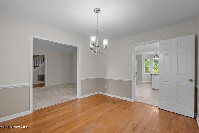 3313 Aster Ct, Wilmington, NC 28409 - spare room with a chandelier, light wood finished floors, and stairway