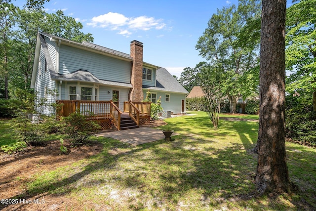 3313 Aster Ct, Wilmington, NC 28409 - back of house featuring a wooden deck, a chimney, a lawn, and a patio