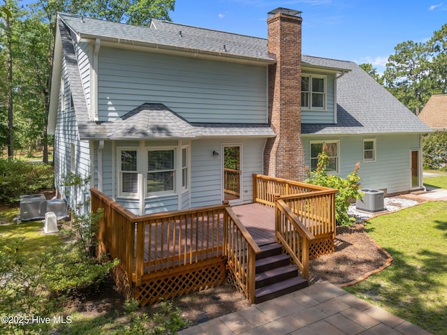 3313 Aster Ct, Wilmington, NC 28409 - rear view of house featuring a chimney, a wooden deck, a shingled roof, and a lawn