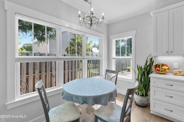 102 SW 4th St, Oak Island, NC 28465 - dining space with a chandelier, crown molding, and light wood finished floors