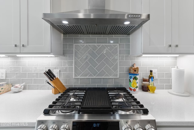 102 SW 4th St, Oak Island, NC 28465 - kitchen with wall chimney range hood, stainless steel stove, tasteful backsplash, and white cabinets