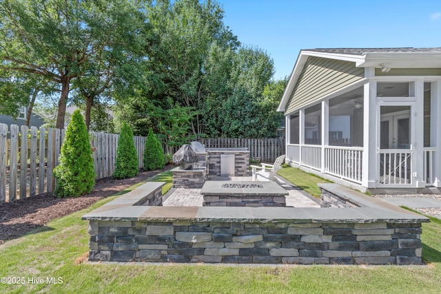 102 SW 4th St, Oak Island, NC 28465 - fenced backyard featuring a fire pit, a sunroom, a patio area, and ceiling fan