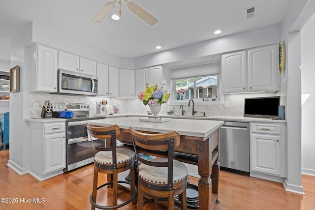 111 Mcginnis Dr, Pine Knoll Shores, NC 28512 - kitchen with appliances with stainless steel finishes, light countertops, light wood-style floors, and recessed lighting