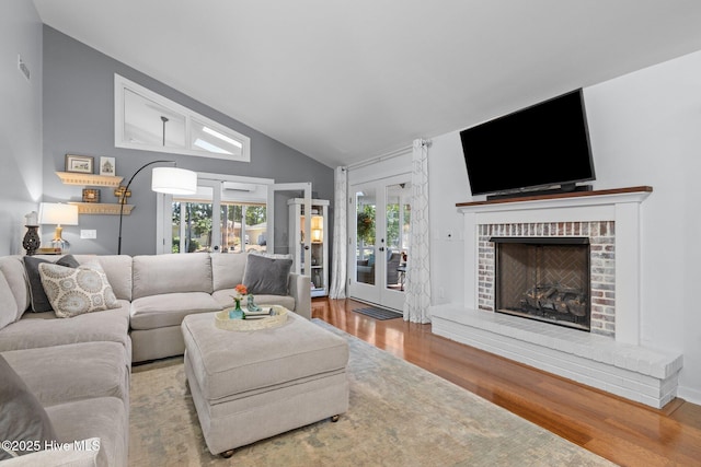 111 Mcginnis Dr, Pine Knoll Shores, NC 28512 - living room featuring french doors, wood finished floors, lofted ceiling, and a fireplace