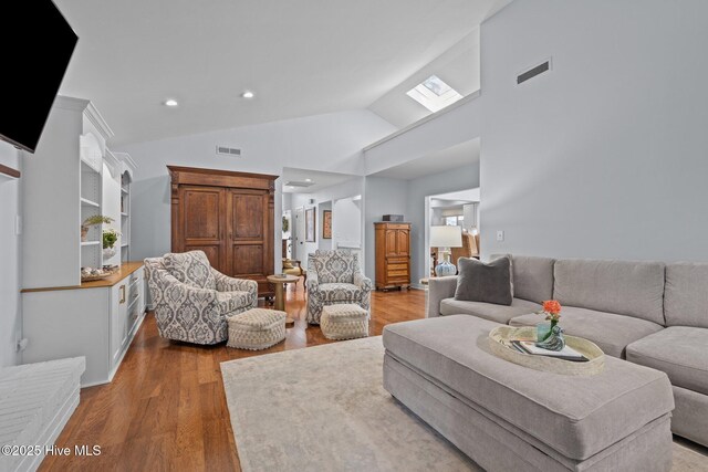 111 Mcginnis Dr, Pine Knoll Shores, NC 28512 - living room with wood finished floors, vaulted ceiling, and recessed lighting