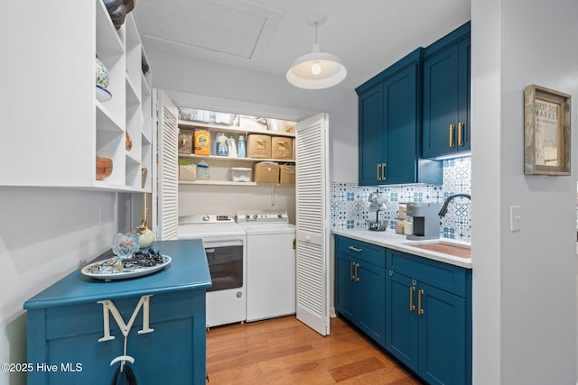 111 Mcginnis Dr, Pine Knoll Shores, NC 28512 - kitchen with blue cabinetry, washing machine and dryer, light wood finished floors, open shelves, and backsplash