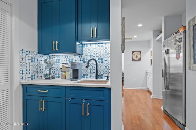 111 Mcginnis Dr, Pine Knoll Shores, NC 28512 - kitchen featuring stainless steel refrigerator with ice dispenser, blue cabinetry, backsplash, light wood-type flooring, and recessed lighting