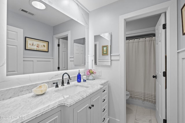 111 Mcginnis Dr, Pine Knoll Shores, NC 28512 - full bath featuring marble look tiles, vanity, a shower with shower curtain, and a wainscoted wall