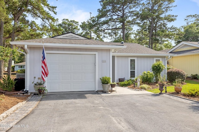 111 Mcginnis Dr, Pine Knoll Shores, NC 28512 - single story home featuring asphalt driveway, an attached garage, and a shingled roof