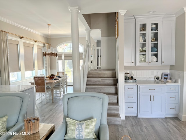 23 Leland St, Ocean Isle Beach, NC 28469 - bar with ornate columns, light wood-style floors, ornamental molding, stairs, and decorative light fixtures