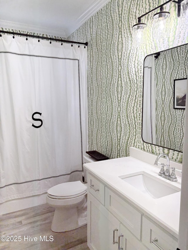 23 Leland St, Ocean Isle Beach, NC 28469 - bathroom with wallpapered walls, vanity, wood finished floors, and crown molding