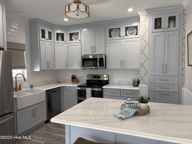 23 Leland St, Ocean Isle Beach, NC 28469 - kitchen with stainless steel appliances, gray cabinetry, decorative backsplash, dark wood-style flooring, and light stone countertops