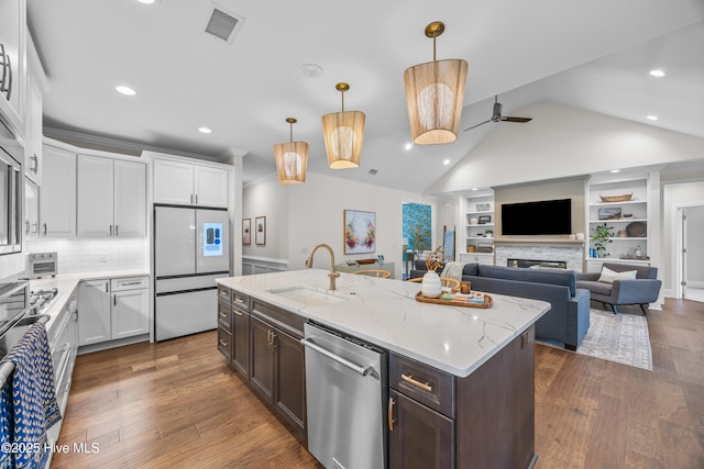 3478 Belle Meade Way NE, Leland, NC 28451 - kitchen with appliances with stainless steel finishes, dark brown cabinets, lofted ceiling, white cabinetry, and built in shelves