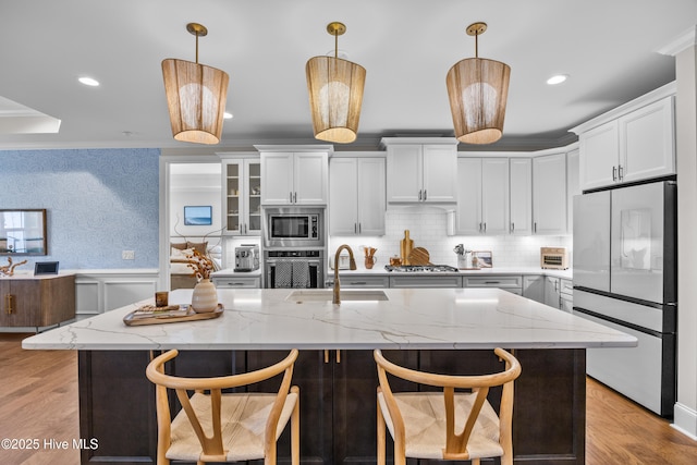 3478 Belle Meade Way NE, Leland, NC 28451 - kitchen featuring stainless steel appliances, wainscoting, pendant lighting, white cabinetry, and light stone counters